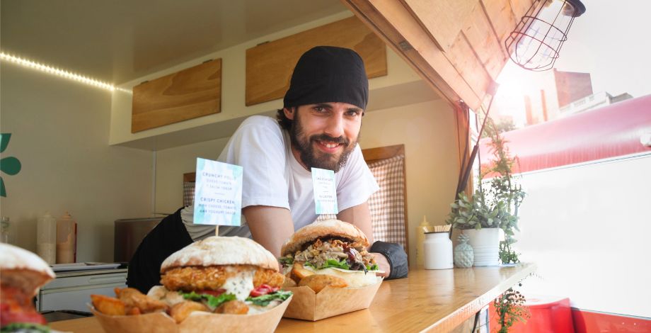 Hombre detrás de un mostrador en un restaurante de hamburquesas.