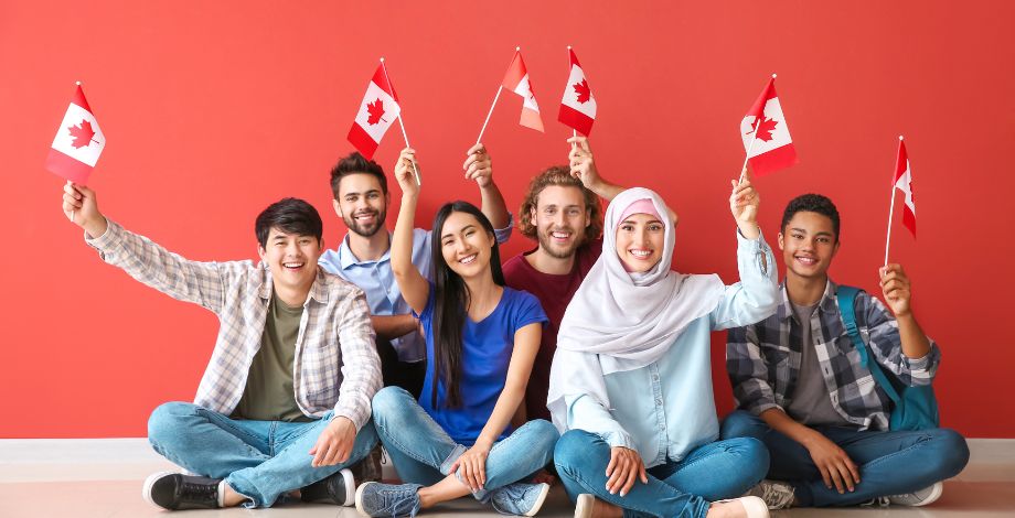 Grupo de jóvenes con bandera de Canadá en mano.